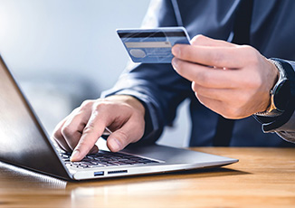 Man holding credit card while making purchase online