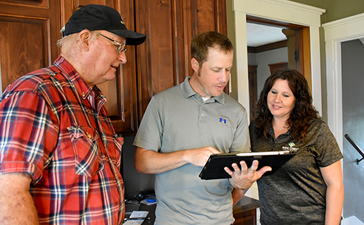 Young farmer looks at tablet with Farm Credit loan officer